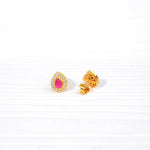 Gold-toned teardrop stud earrings with pink stone and clear crystal accents on white background
