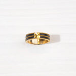 Gold-plated silver ring with black enamel stripes and central floral design on white background