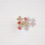 Gold plated silver ring with floral shapes, ruby red stones, and clear baguette crystals