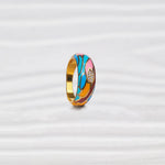 Colorful gold-plated silver ring with blue, pink, orange enamel and small stones on white background