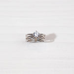 Sterling silver ring with solitaire round clear gemstone on white background