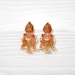 Traditional gold-plated jhumka earrings with intricate detailing and pearl dangles