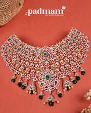 Intricate 92.5 silver choker necklace with green gemstones and gold detailing on terracotta background