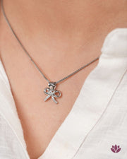 92.5 silver bow pendant necklace on a woman wearing a white top