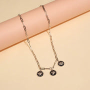 92.5 silver chain necklace with three black enamel star pendants on a neutral background