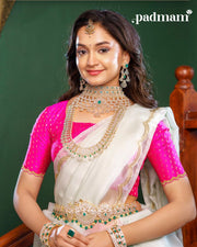 Woman in traditional Indian attire wearing layered 92.5 silver jewelry with green stones
