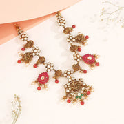 Traditional Indian silver necklace with red gemstones, white kundan stones, and floral motifs